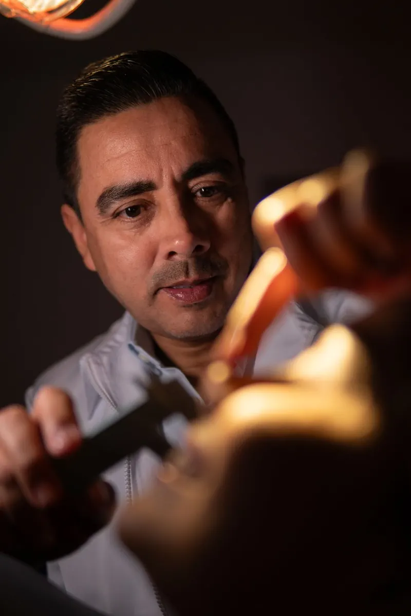 El Dr. Ramírez concentrado en su trabajo bajo la lámpara del consultorio de Cirumax