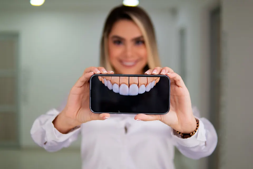 Profesional de Cirumax mostrando en su celular la imagen de una sonrisa